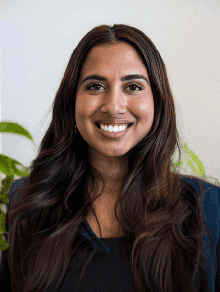 Professional headshot of a smiling woman with long dark hair wearing a navy blue top